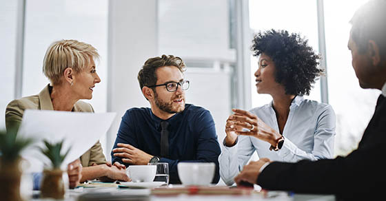 Give us difficult and well show you easy. Shot of a group of businesspeople sitting together in a meeting.