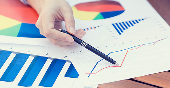 Closeup female hands pointing with pen at business document, financial report while discussing company profit growth. Businesspeople, stockholders meeting in corporate office, concept. Wall street