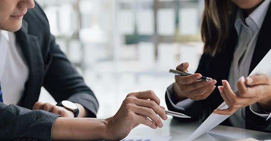 Meeting of business consultants discussing analysis of financial graphs and charts. Analysis of market growth data and investment planning.