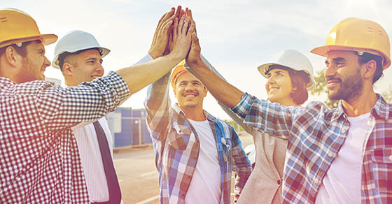 business, building, partnership, gesture and people concept - close up of smiling builders and architects in hardhats making high five outdoors