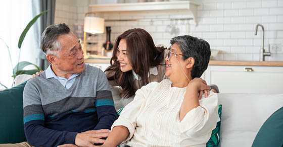 Portrait of Loving Asian Family , Mature Asian Parents with Young Daughter on sofa in living room at home