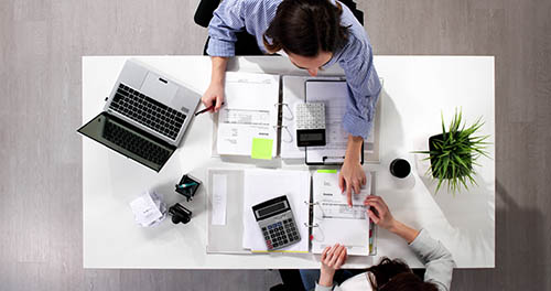 Busy accountants working on tax audits and compliance in the office. Invoicing, advising, and budgeting for a successful business. Female accountant.